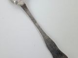 a spoon that is sitting on a white surface