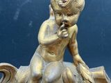 a statue of a boy sitting on top of a clock
