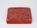 a red box with a design on it sitting on a white surface