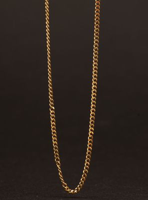 un collier à chaîne en or avec un fermoir carré sur fond noir