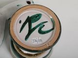 a white plate with green writing on it next to a white plate with green writing on it