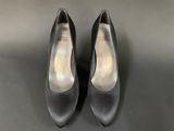 a pair of women ' s black shoes on a black surface