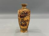 a small vase with a painting on it sitting on a table