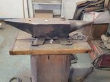a metal anvil sitting on a table in a workshop