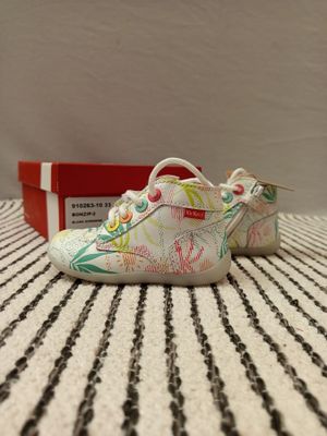 un gros plan sur une paire de chaussures posées sur une surface rayée