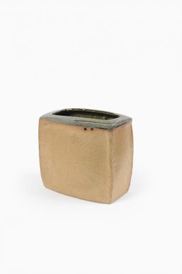 une petite jardinière posée sur une surface blanche