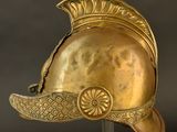 an antique helmet with a golden decoration on a stand