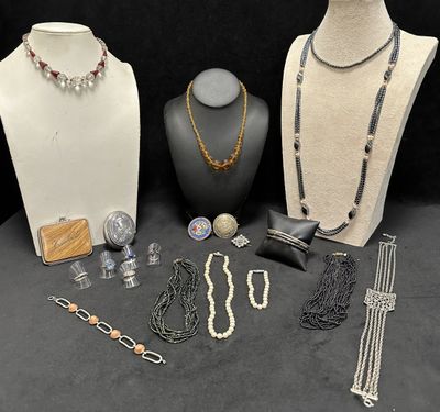 many different necklaces and bracelets on display on a table