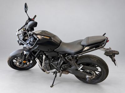 a black motorcycle that is parked on a white floor
