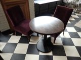 two chairs and a table in a room with a checkered floor