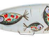 a plate with a fish design on it on a stand