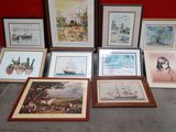 a lot of framed pictures on the floor next to a red wall