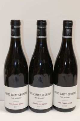 trois bouteilles de vin sont alignées sur une table