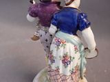 a figurine of a man and a woman holding flowers