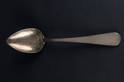 a spoon that is sitting on a black surface