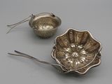 two silverware items including a bowl, spoon and spoon rest