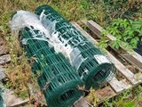 de nombreux rouleaux de plastique posés sur une palette dans l'herbe