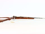 un fusil avec un canon en bois sur fond blanc