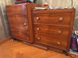 une commode en bois avec des tiroirs, sur laquelle est posé un ordinateur portable