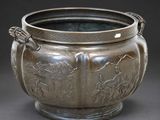 a large metal pot with a handle on a table