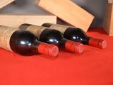 several bottles of wine are lined up on a red table