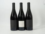 three bottles of wine sit on a white surface with a white background