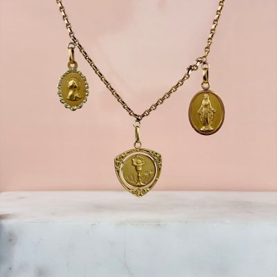 a gold necklace with three charms on it