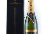 une bouteille de champagne Moët à côté d'une boîte noire