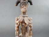 a close up of a statue of a person sitting on a chair
