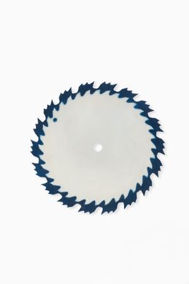 a close up of a circular saw blade on a white surface