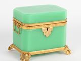 boîte vert turquoise avec des bordures et des poignées dorées sur fond blanc