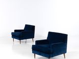 une paire de fauteuils de salon en velours bleu avec des pieds en noyer