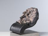 un gros plan d'une sculpture représentant un rocher posé sur un socle métallique