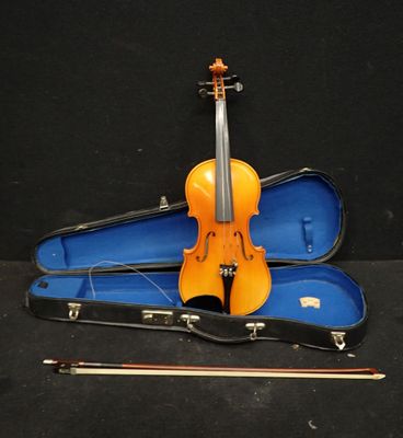 un violon et un étui à violon posés sur une surface noire