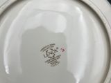 a white bowl that has a black and red design on it