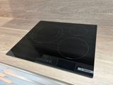une cuisinière noire à trois brûleurs