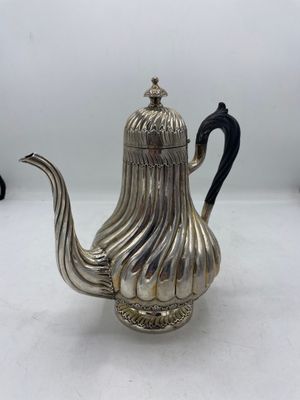 une théière en argent avec une anse noire sur un fond blanc