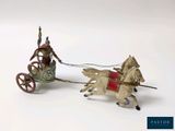 two figurines of a man riding on a horse drawn carriage