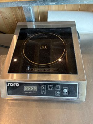 une photo d'une plaque de cuisson posée sur un plan de travail dans une cuisine