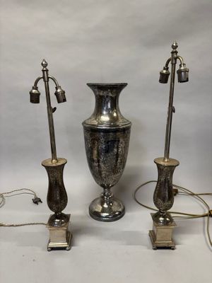 trois vases en argent posés l'un à côté de l'autre sur une table