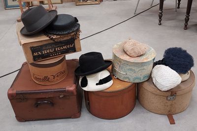 un tas de chapeaux et de valises posés par terre