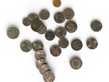some coins are scattered on a white surface with a coin in the foreground