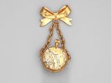 a close up of a pocket watch on a chain with a bow