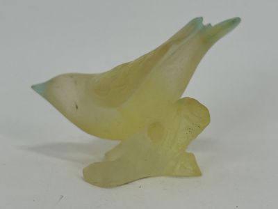 a yellow bird that is sitting on a white table