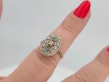 an image of a woman ' s hand with a red manicure holding a diamond and emerald ring