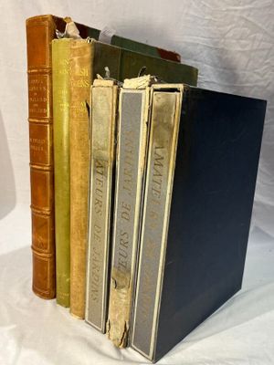 several old books are stacked on top of each other on a white surface