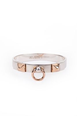 un gros plan d'une bague en argent et en or sur fond blanc