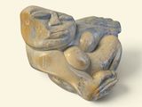 une sculpture en pierre représentant un homme allongé sur le dos