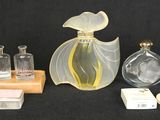 three bottles of perfume on a table with a wooden stand