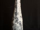 un vase noir et blanc posé sur une table noire